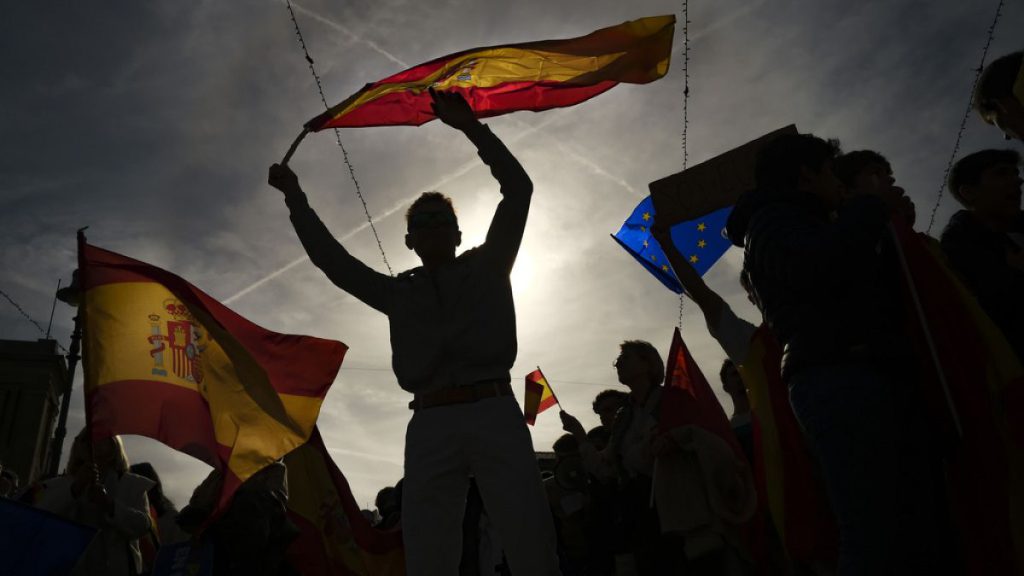 Demonstrators waves Spanish flags at Plaza del castillo square during a protest called by Spain