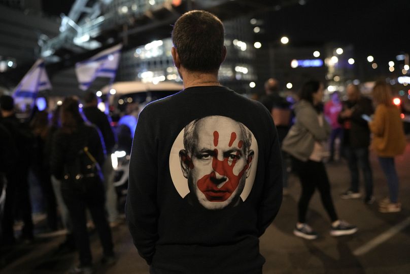 Protestujący ma na sobie koszulkę przedstawiającą premiera Izraela Benjamina Netanjahu próbującego podczas demonstracji zażądać uwolnienia zakładników wziętych przez bojowników Hamasu