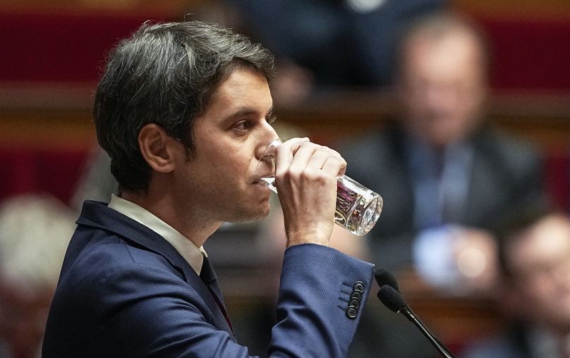Premier Francji Gabriel Attal wypija szklankę wody podczas przemówienia do prawodawców w Zgromadzeniu Narodowym w Paryżu.