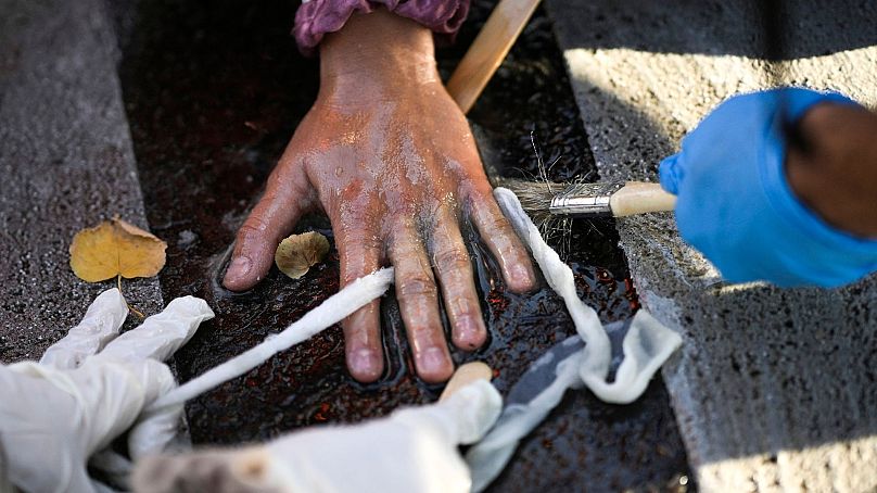 Policjanci usuwają z drogi przyklejoną rękę działacza klimatycznego podczas protestu klimatycznego w Berlinie, Niemcy, 28 września 2023 r.