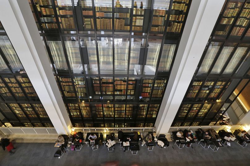 Ludzie pracują za tłem książek w Bibliotece Brytyjskiej