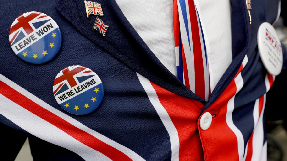 Brexit supporter wears badges as he demonstrates outside Parliament in London, Oct. 28, 2019.