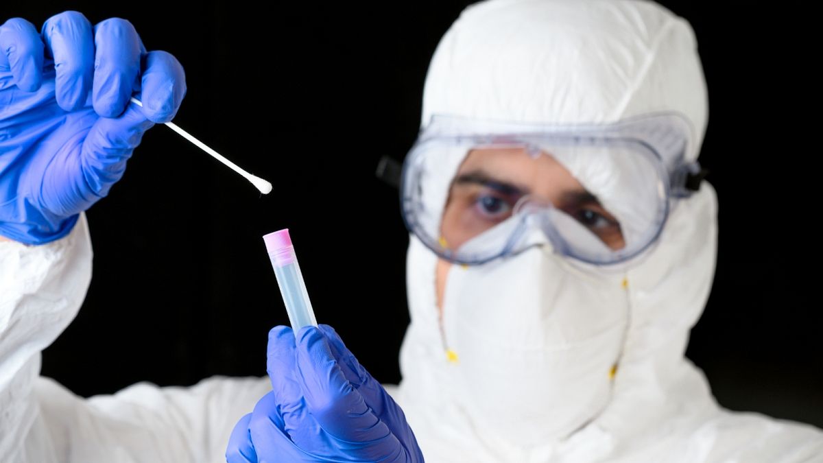 A healthcare worker dresses up in personal protective equipment (PPE).