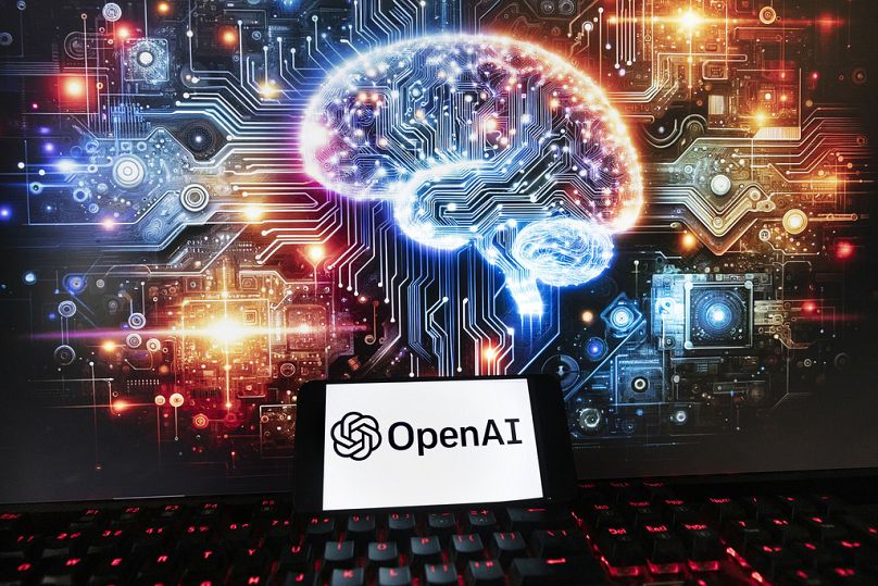 Logo OpenAI jest wyświetlane na telefonie komórkowym wraz z obrazem na ekranie komputera wygenerowanym przez model obrazu tekstowego Dall-E firmy ChatGPT, piątek, 8 grudnia 2023 r., Boston.