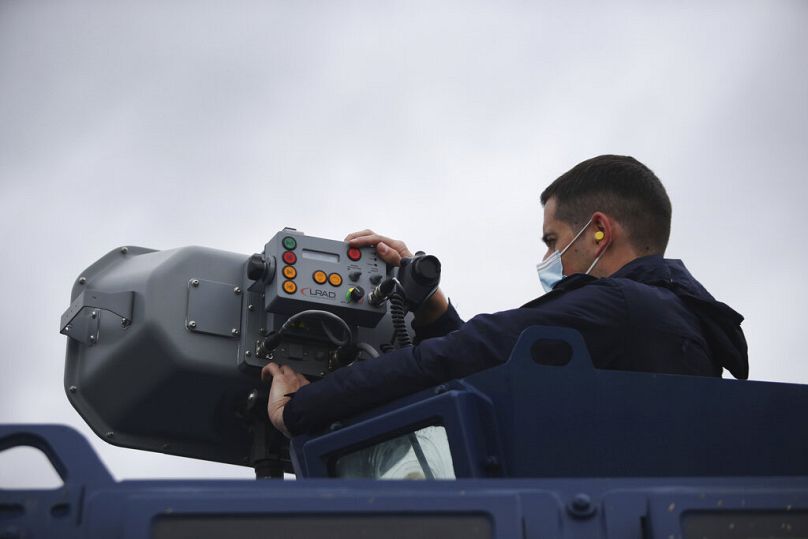 Grecki policjant obsługuje urządzenie akustyczne dalekiego zasięgu LRAD podczas patrolu wzdłuż granicy grecko-tureckiej w pobliżu miasta Feres, maj 2021 r.