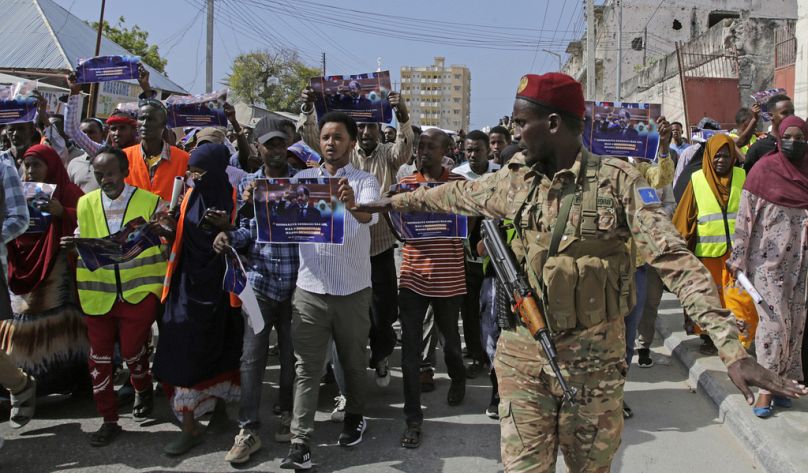 Somalijski żołnierz kontroluje tłum podczas wiecu protestacyjnego w Mogadiszu, styczeń 2024 r.