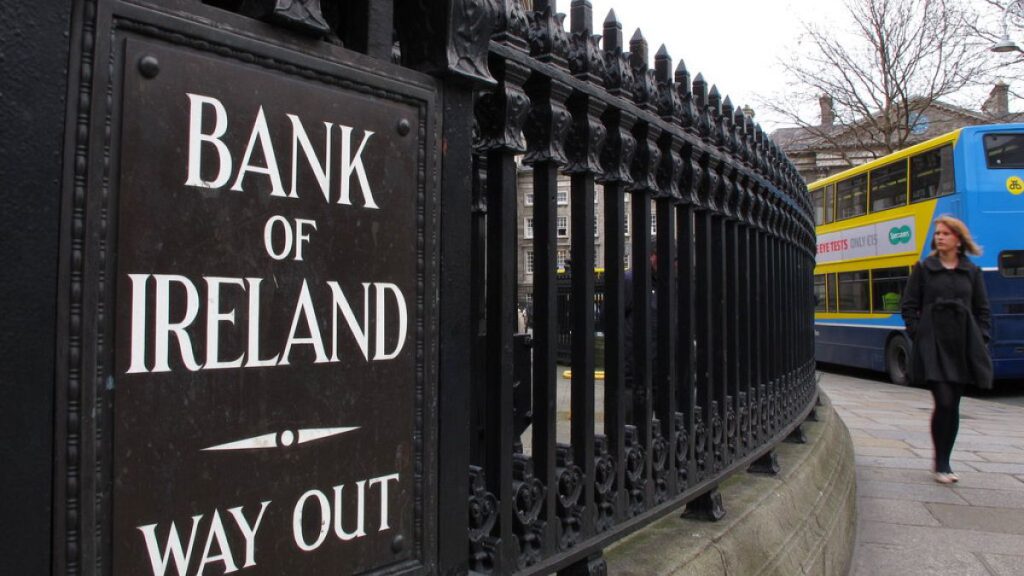 A woman walks past the offices of Bank of Ireland Monday Feb 20 2012.