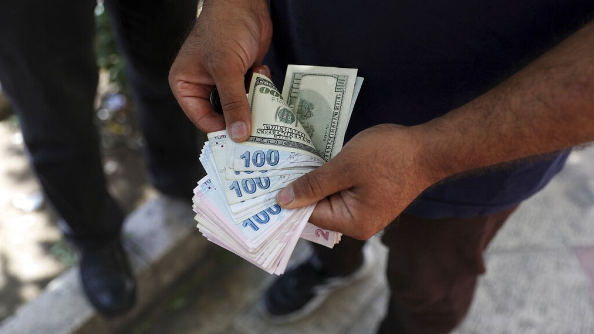 A street money exchanger poses for a photo without showing his face as he counts foreign banknotes in Ferdowsi street, Tehran