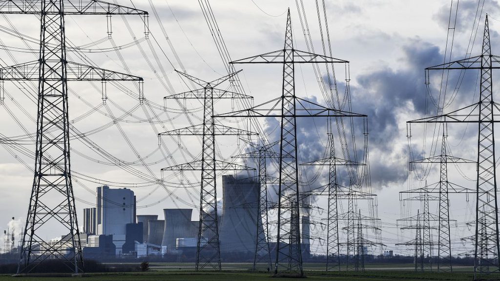 The RWE Niederaussem lignite-fired power station steams behind power poles in Bergheim, Germany, January 2020.