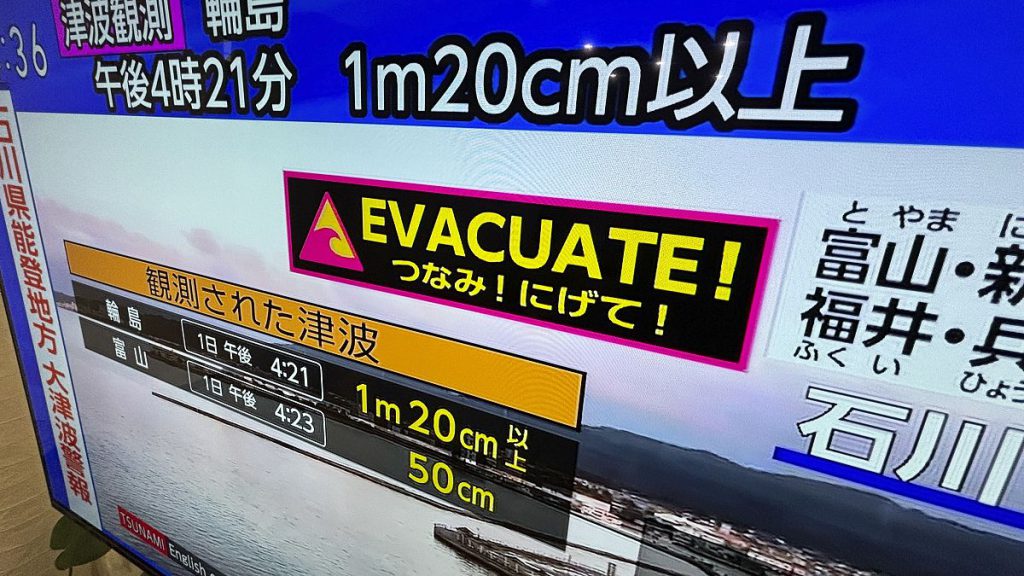 A tsunami warning is shown on TV in Yokohama, near Tokyo Monday, Jan. 1, 2024.