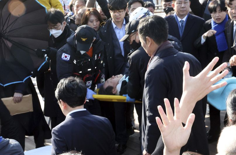 Lider południowokoreańskiej opozycji Lee Jae-myung na noszach jest niesiony przez zespół ratunkowy w Busan w Korei Południowej