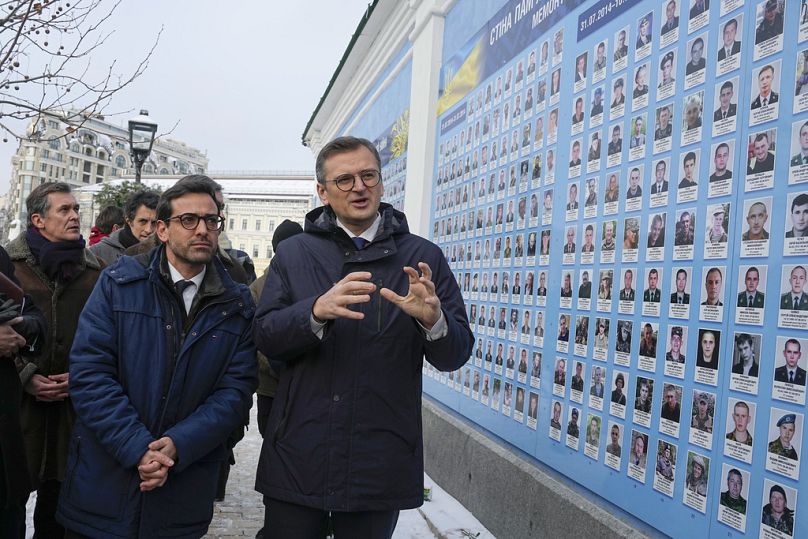 Minister spraw zagranicznych Ukrainy Dmytro Kuleba (z prawej) i jego francuski odpowiednik Stephane Sejourne (z lewej strony) odwiedzają Ścianę Pamięci Poległych Obrońców Ukrainy w Kijowie