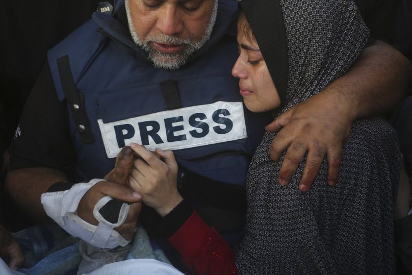 Dziennikarz Al Jazeera Wael Dahdouh trzyma za rękę swojego syna Hamzę, który również pracował dla Al Jazeery i który zginął w niedzielę w izraelskim nalocie w Rafah w Strefie Gazy