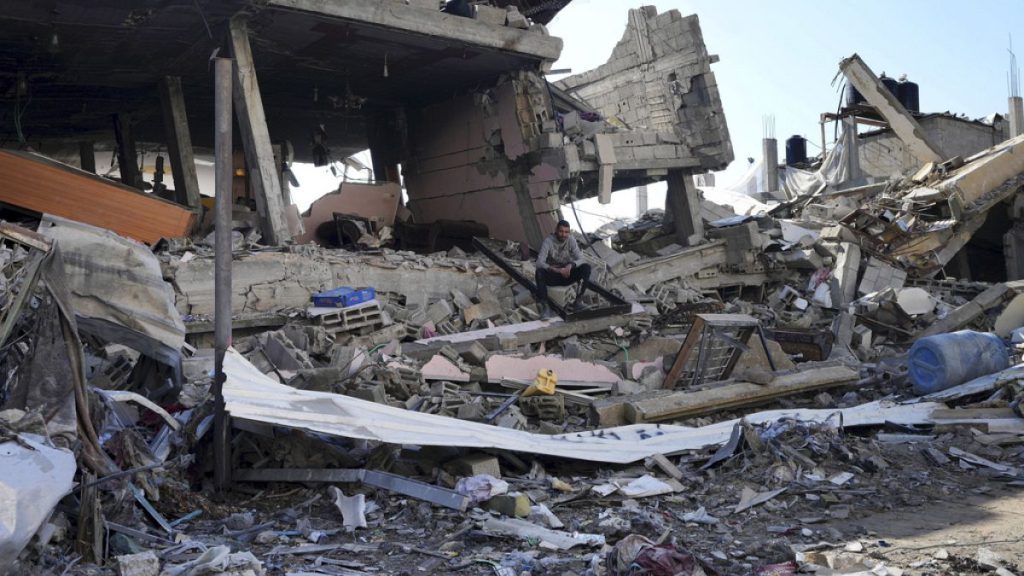 A Palestinian sits among destruction from the Israeli bombardment in the Nusseirat refugee camp in Gaza