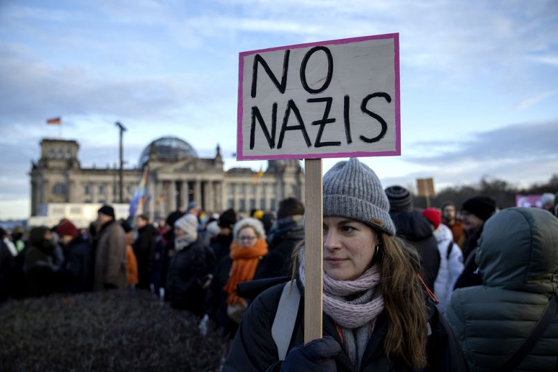 Ludzie zbierają się, protestując przeciwko partii AfD i prawicowemu ekstremizmowi przed budynkiem Reichstagu w Berlinie w Niemczech.