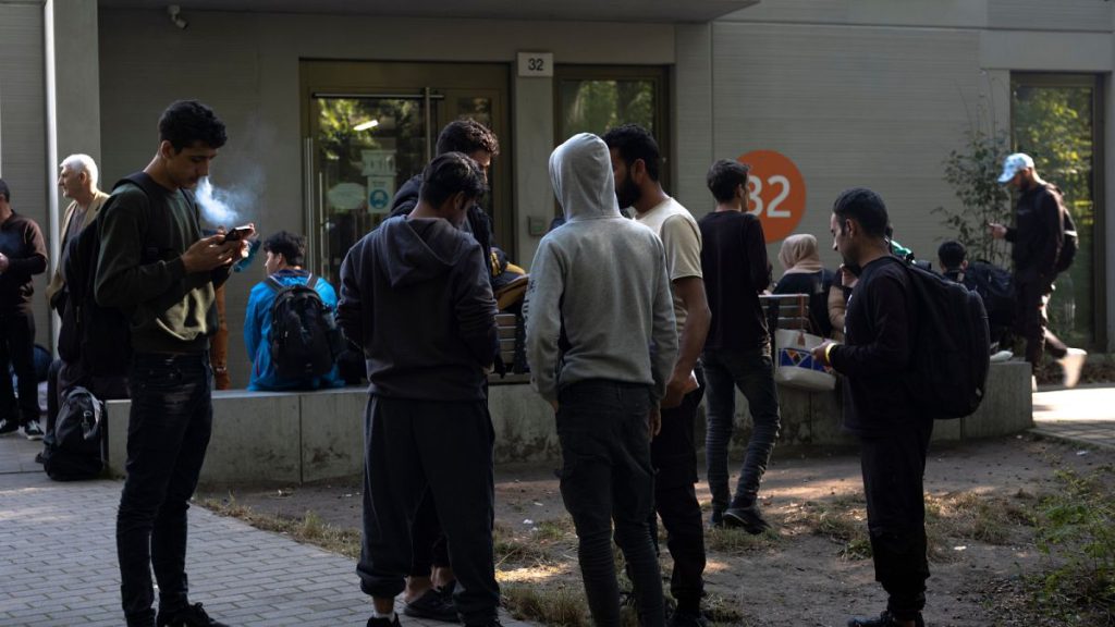 FILE - Dozens of people from all over the world line in front of the central registration center for asylum seekers in Berlin, Germany, Monday, Sept. 25, 2023.