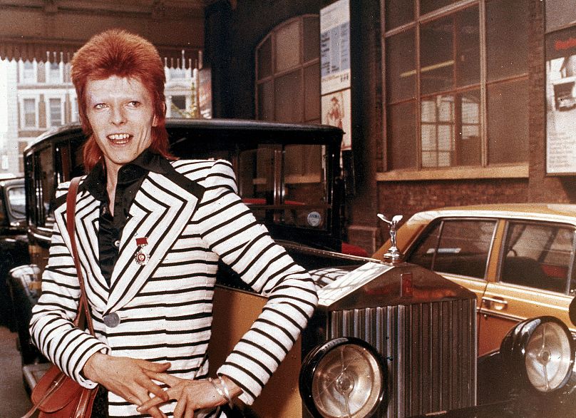 Brytyjski piosenkarz rockowy David Bowie pozuje obok swojego weterana Rolls Royce’a przed wyjazdem na brytyjską trasę koncertową 15 maja 1973 roku.