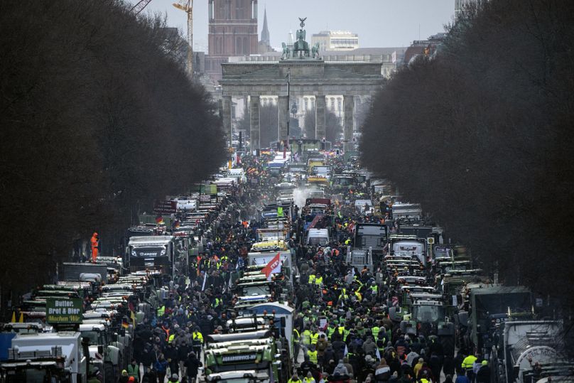 Rolnicy z traktorami przybywają na protest pod Bramą Brandenburską w Berlinie, Niemcy, poniedziałek, 15 stycznia 2024 r.