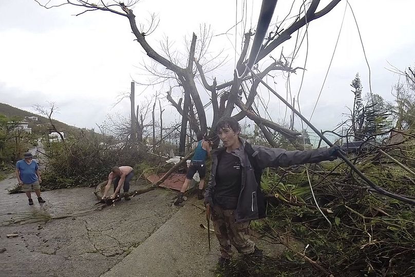 Sąsiedzi sprzątają gruz z drogi po huraganie Irma w St. Thomas, USVI, wrzesień 2017 r.