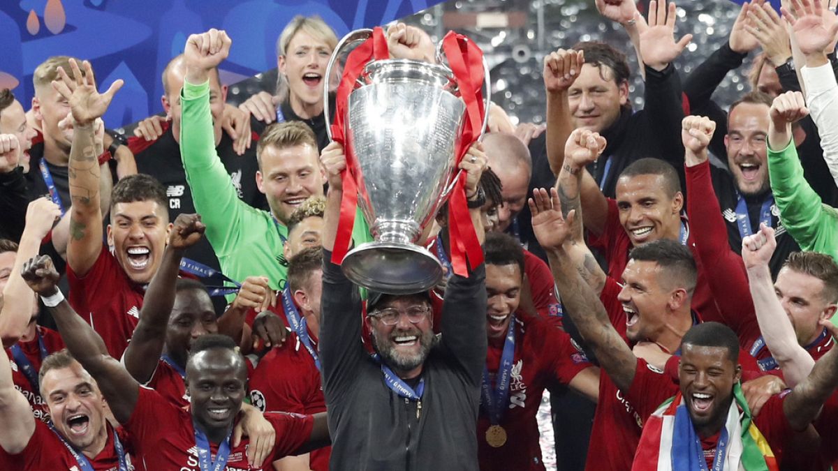 Liverpool coach Juergen Klopp lifts up the trophy as he celebrates with players after winning the Champions League final soccer match between Tottenham Hotspur and Liverpool
