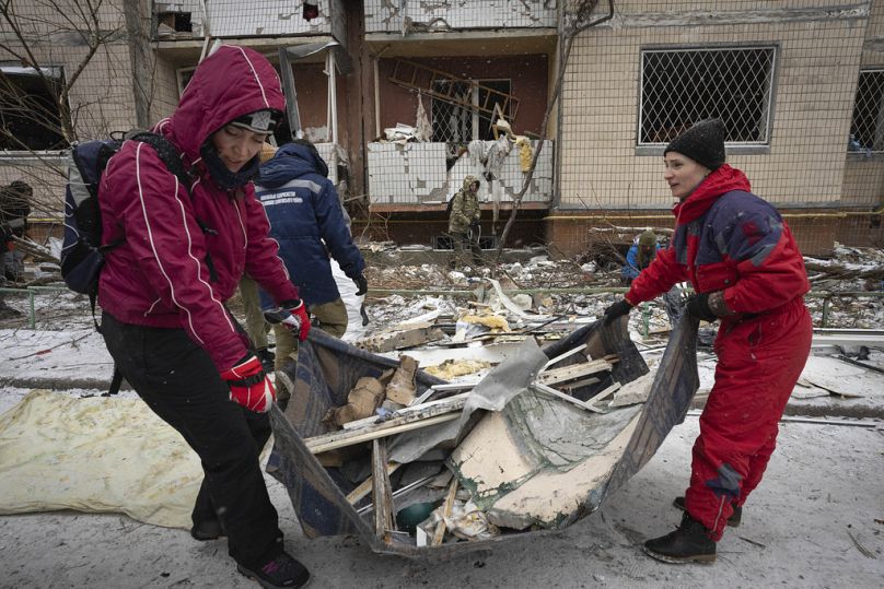 Wolontariusze i mieszkańcy sprzątają gruz budynku mieszkalnego poważnie uszkodzonego po wtorkowym rosyjskim ataku rakietowym w Kijowie na Ukrainie, środa, 3 stycznia 2024 r.