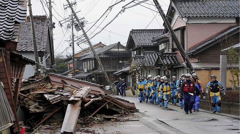 Policja mija zawalone domy dotknięte trzęsieniem ziemi w Suzu, prefektura Ishikawa, Japonia, środa, 3 stycznia 2024 r.