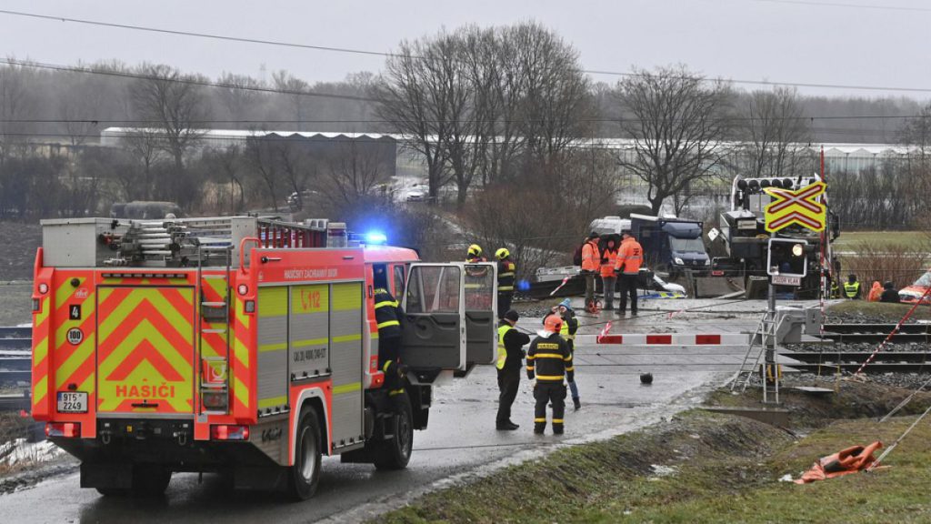 Policemen and railway inspectorate staff work at the scene of a train crash where a fast train collided with a truck at a level crossing in Dolni Lutyne, Czech Republic