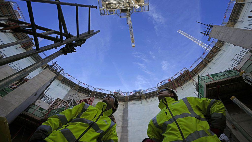 Employees look up at the construction site of Hinkley Point C nuclear power station in Somerset, England, Tuesday, Oct. 11, 2022.