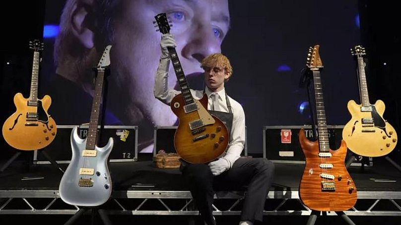 Pracownik Christie's pokazuje gitarę Gibson Kalamazoo, należącą między innymi do piosenkarza i autora tekstów Dire Straits Marka Knopflera