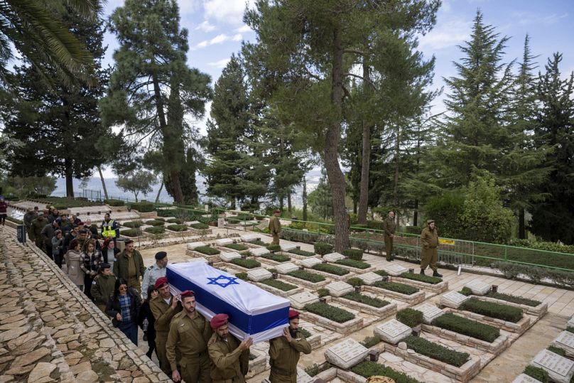 Izraelscy żołnierze niosą udekorowaną flagą trumnę rezerwisty Gavriela Shaniego podczas jego pogrzebu na cmentarzu wojskowym na górze Herzl w Jerozolimie
