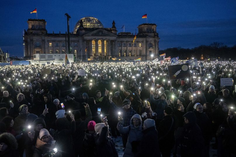 PLIK – Ludzie trzymają telefony komórkowe podczas protestu przeciwko partii AfD i prawicowemu ekstremizmowi przed budynkiem Reichstagu w Berlinie, 21 stycznia 2024 r.