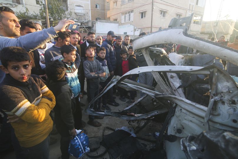 Palestyńczycy gromadzą się wokół policyjnego pojazdu Hamasu po uderzeniu w niego izraelskim nalotem w Rafah w Strefie Gazy.