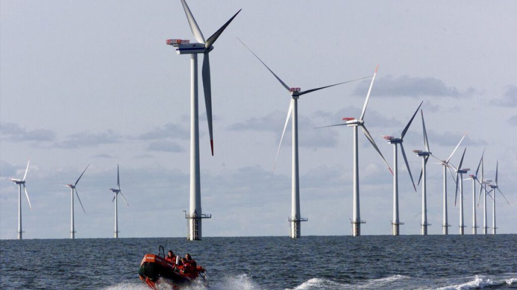 A speed boat passes by offshore windmills in the North Sea offshore from the village of Blavandshuk near Esbjerg, Denmark in this file photo