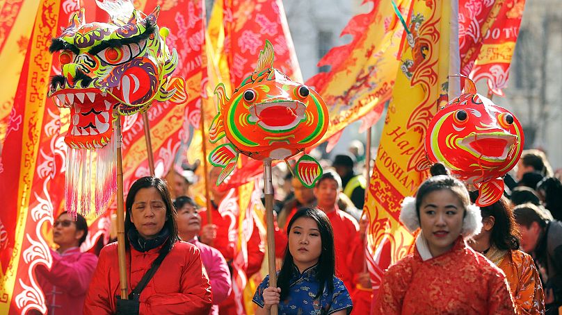 Ludzie w kostiumach przyłączają się do parady z okazji chińskiego Nowego Roku, Roku Psa, w dzielnicy Chinatown w Londynie