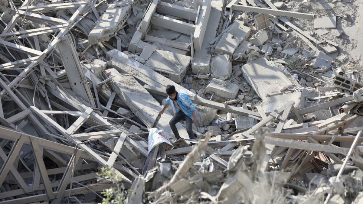 Palestinians walk through the destruction left by the Israeli air and ground offensive on the Gaza Strip in Gaza City, Saturday, Feb. 10, 2024.