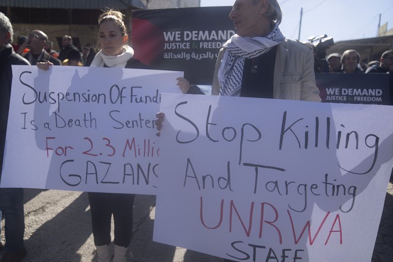 Palestyńczycy protestują przeciwko zawieszeniu funduszy kilku krajów-darczyńców na rzecz UNRWA przed biurami Agencji w mieście Beitunia na Zachodnim Brzegu, luty 2024 r.