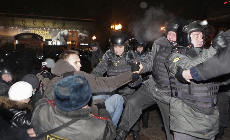 PLIK – Policja zatrzymuje przywódcę protestów Aleksieja Nawalnego, widzianego w kurtce z kapturem, po wiecu na placu Puszkina w Moskwie, poniedziałek, 5 marca 2012 r.