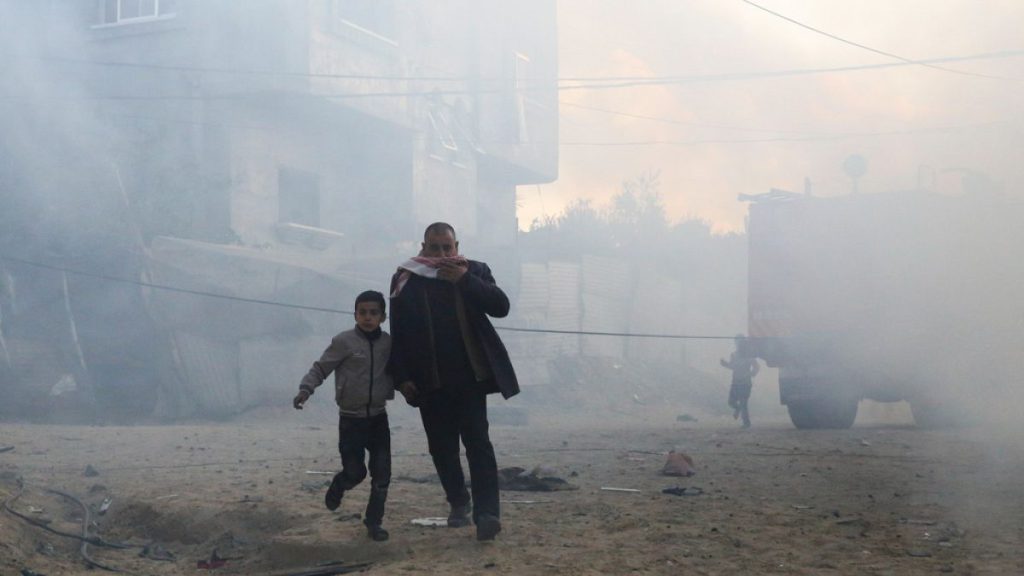 Palestinians run away after an Israeli strike on a residential building in Rafah, Monday, Feb. 19, 2024.