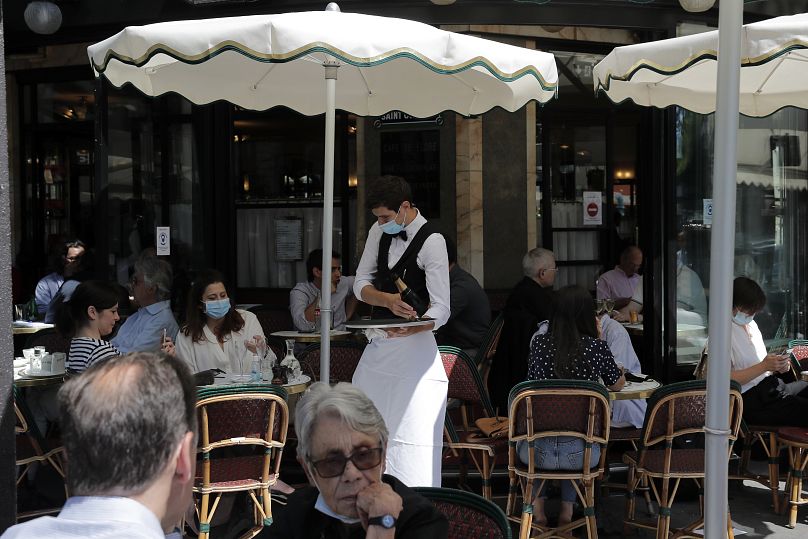 Ludzie siedzą na tarasie Cafe de Flore w Paryżu, wtorek, 2 czerwca 2020 r.