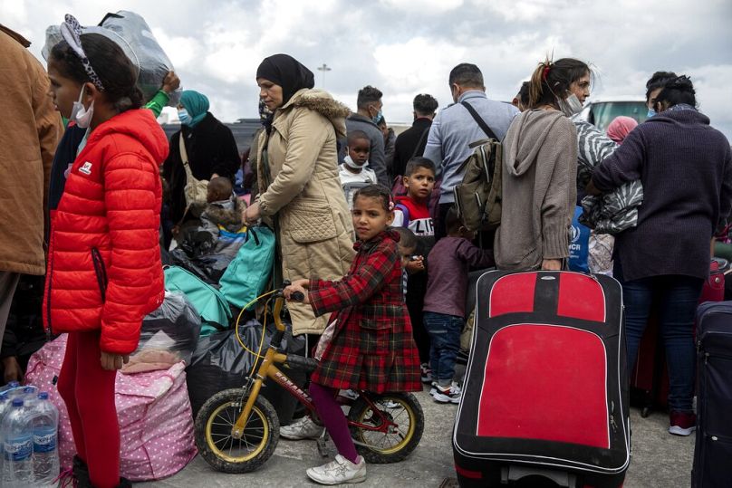 Migranci z obozów ze wschodnich wysp Morza Egejskiego czekają na wejście do autobusów po zejściu ze statku w porcie Lavrio, listopad 2020 r.
