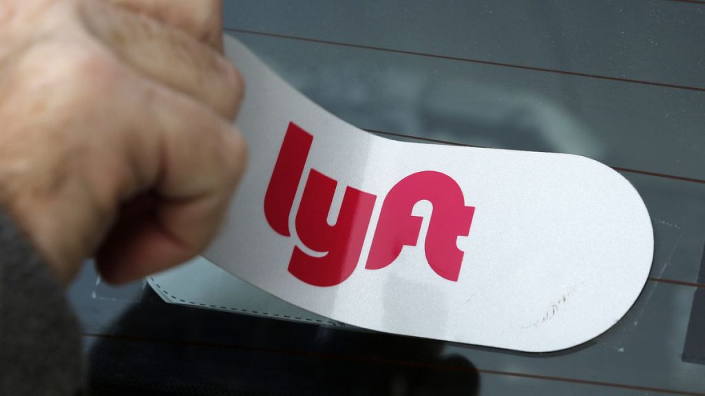 In this Jan. 31, 2018, file photo, a Lyft logo is installed on a Lyft driver