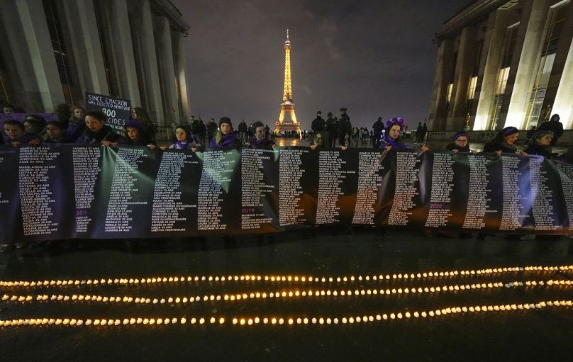 Członkinie grupy kobiet #NousToutes trzymają baner z nazwiskami 900 kobiet zabitych przez swoich partnerów w Trocadero Plaza w pobliżu Wieży Eiffla, czwartek, 8 lutego 2024 r.