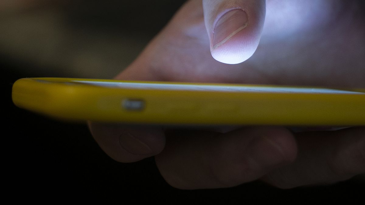 FILE - A man uses a cellphone in New Orleans, August 11, 2019