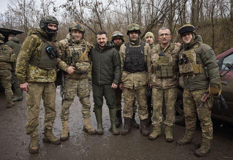 Prezydent Ukrainy Wołodymyr Zełenski (w środku) pozuje do zdjęcia z żołnierzami podczas swojej wizyty w obwodzie zaporoskim, miejscu zaciętych walk z wojskami rosyjskimi.