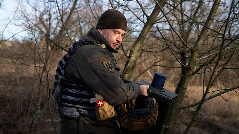 Ukraiński żołnierz instaluje elektroniczny system walki, aby stłumić rosyjskie drony na linii frontu w pobliżu Bachmutu w obwodzie donieckim na Ukrainie.