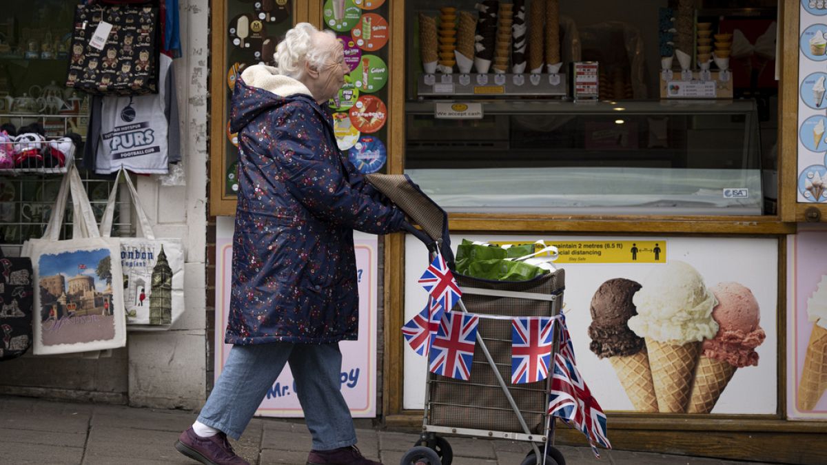 A older woman pushes a trolley decorated with Union Jack flags in Windsor. May 5, 2023.