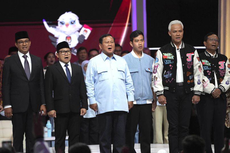 Kandydaci na prezydenta stoją na scenie i śpiewają piosenkę narodową "Dla Ciebie, Mój Kraj" po transmitowanej przez telewizję debacie kandydatów na prezydenta w Dżakarcie, luty 2024 r