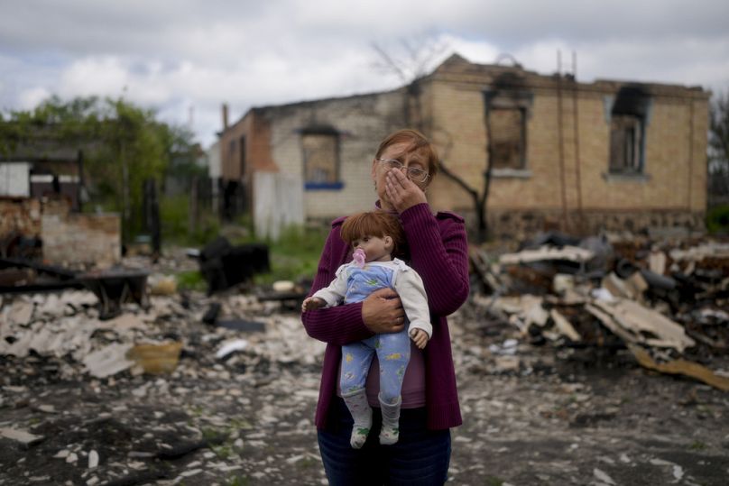 Nila Zelińska trzyma lalkę należącą do jej wnuczki, którą znalazła w zniszczonym domu w Potaszni na przedmieściach Kijowa, maj 2022