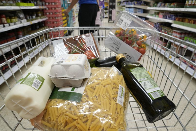 Kosz artykułów spożywczych w wózku w supermarkecie w Londynie, czerwiec 2023 r