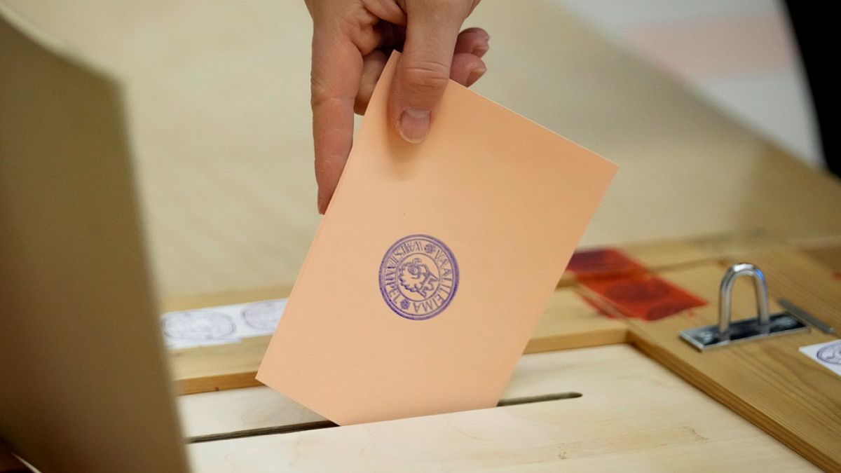 A woman casts her ballot at a polling station during a presidential election in Espoo, Finland, Sunday, Feb. 11, 2024.